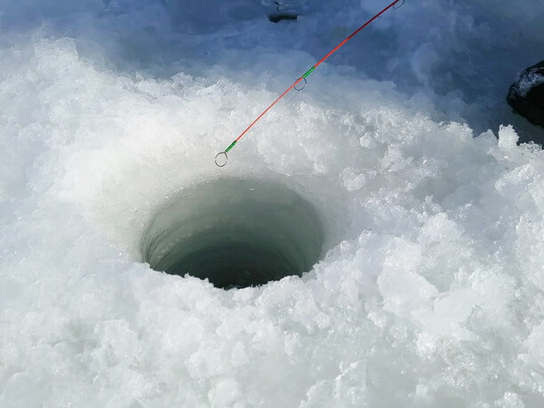 氷の穴から釣り糸を垂らす