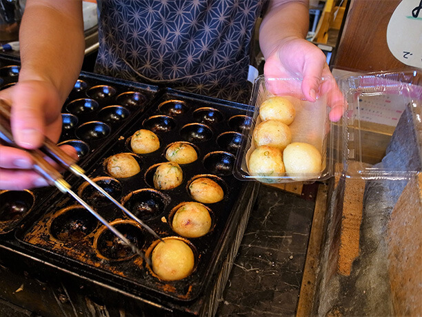 焼きあがったたこ焼きをパックに入れている様子