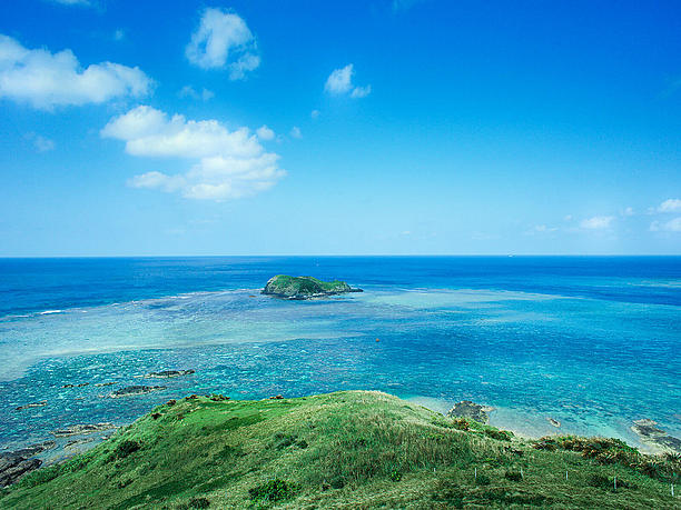 灯台の立つ小さな丘から一面の海を見渡す