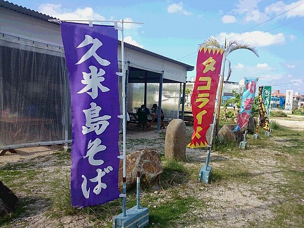 久米島そばやタコライスののぼりが立っているスリーピース前