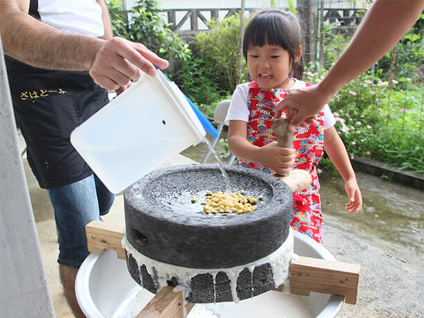 ひと晩水に浸けた大豆を石臼でひいていく様子