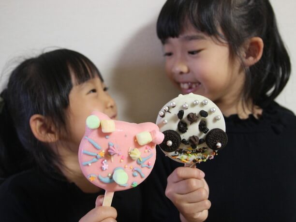 冷やされたアイスバーを持った子どもたち