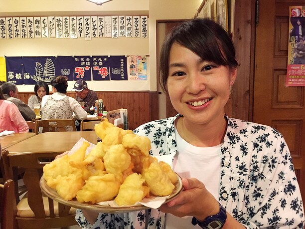 てんこ盛りの天ぷらを勧める女性地元民　イクコさん