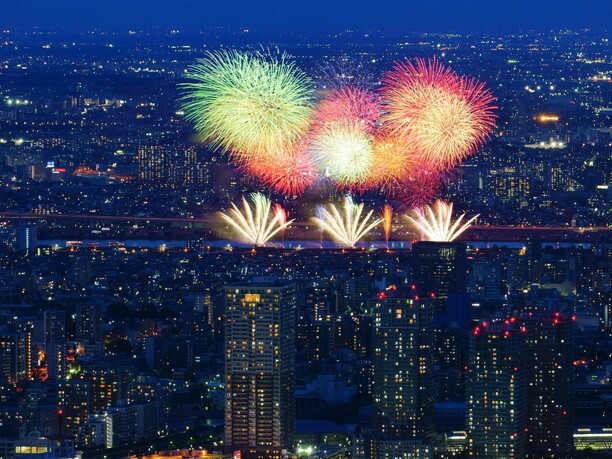 東京スカイツリーや高層ビル群の夜景をバックに